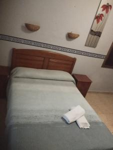 Una cama con dos toallas encima. en Hospedería Lucano, en Córdoba