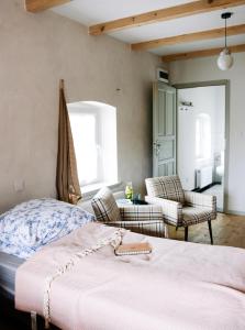 1 dormitorio con 1 cama y sillas en una habitación en Dwie Brzozy wegetariańskie siedlisko en Wleń