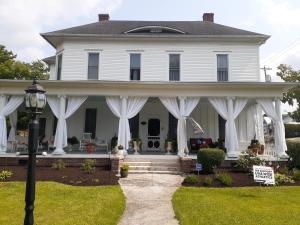 a white house with white drapes on the porch at Queens Chamber w King Heavenly Bed at Nottingham Place in Wise in Wise