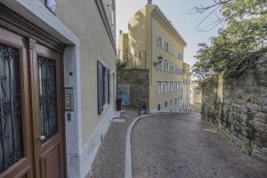 an empty street in an alley with buildings at Monte 21 - San Giusto in Trieste