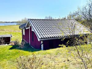 a red barn sitting on a grassy hill in a field at 4 person holiday home in ALVESTA-By Traum in Alvesta +16 photos