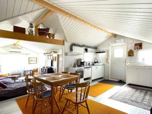 Holiday home ALVESTA II في الفيستا: مطبخ وغرفة معيشة مع طاولة وكراسي