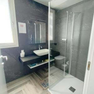 a bathroom with a shower and a sink and a toilet at Stanza idromassaggio in Quartu SantʼElena