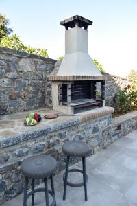 two stools sitting in front of a brick oven at Sunlight Residence in Kalo Chorio