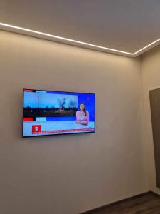 a flat screen tv hanging on a wall at Centro apartamentai in Panevėžys