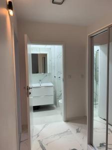 a white bathroom with a sink and a mirror at Apart 86B Angielska Grobla 5 - Gdańsk Śródmieście in Gdańsk