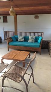 uma sala de estar com um sofá, uma mesa e uma cadeira em Ohana Praia do Forte na Praia do Forte