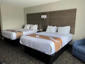 two beds in a hotel room with a blue couch at Quality Inn & Suites Red Wing in Red Wing +27 photos