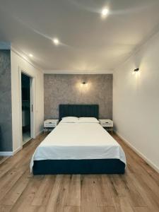 - une chambre avec un grand lit et 2 tables dans l'établissement Studio Glen, à Târgu-Mureş