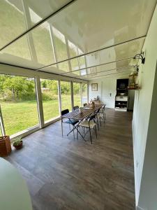 - une salle à manger avec une table, des chaises et des fenêtres dans l'établissement la maison d'hôtes des Charentes, à Les Touches-de-Périgny