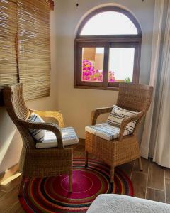ein Wohnzimmer mit zwei Stühlen und einem Fenster in der Unterkunft Hotel Boutique casa la Malagueña in San Agustinillo