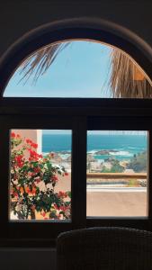 ein Fenster mit Blick auf den Strand und das Meer in der Unterkunft Hotel Boutique casa la Malagueña in San Agustinillo