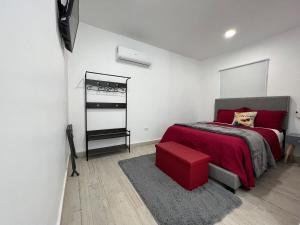 een slaapkamer met een rood bed en een rode kruk bij Las Mariposas Mini Suites in Rosarito