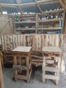 Habitación con mesas de madera y taburetes en un edificio en Cozy Huts, en Nyandarua 