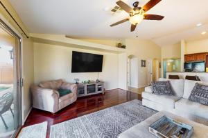 a living room with two couches and a flat screen tv at Blue Umbrella Retreat in Avondale