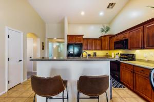 a kitchen with wooden cabinets and a island with bar stools at Blue Umbrella Retreat in Avondale
