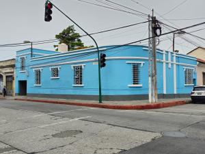 een blauw gebouw op de hoek van een straat bij Hotel Asunción in Guatemala