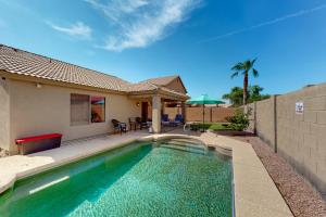 a swimming pool in front of a house at Blue Umbrella Retreat in Avondale