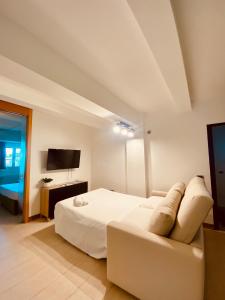 una camera con un letto bianco e un divano di Leaf Apartment a Ravenna
