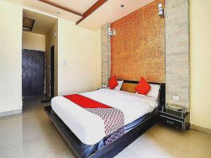 - une chambre avec un grand lit et des oreillers rouges dans l'établissement 7R Resort, à Jaipur