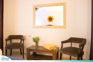 Zimmer mit 2 Stühlen und einem Tisch mit einem Spiegel in der Unterkunft Pool Terrace, Deluxe E1, Close to Beach, 2Br, 2Bt in Punta Cana