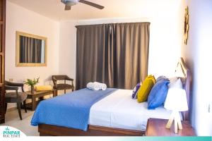 Schlafzimmer mit einem Bett mit blauen und gelben Kissen in der Unterkunft Pool Terrace, Deluxe E1, Close to Beach, 2Br, 2Bt in Punta Cana