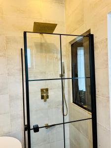 y baño con ducha y puerta de cristal. en La Villa Saint Jean en Cotonú