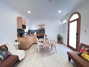 een woonkamer met een tafel en een keuken bij Las Mariposas Mini Suites in Rosarito