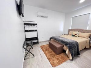 een slaapkamer met een bed en een flatscreen-tv bij Las Mariposas Mini Suites in Rosarito