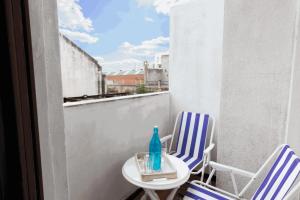 een balkon met 2 stoelen, een tafel en een fles bij The Wall Montevideo [001] Live in The Old Town in Montevideo