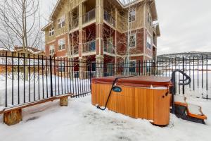 un bâtiment avec une clôture et un banc dans la neige dans l'établissement Village Retreat, à Granby