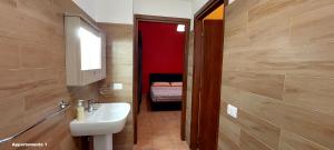 a bathroom with a sink and a bed in a room at Residence Il Vicoletto in Brolo