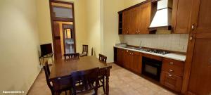 a kitchen with wooden cabinets and a wooden table at Residence Il Vicoletto in Brolo