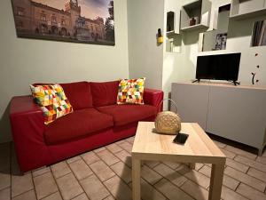 sala de estar con sofá rojo y mesa en Incanto, en Parma