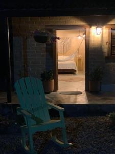 una silla azul sentada en el porche de un dormitorio en Privada y comoda cabaña, Casa Margarita, Villavieja, en Villavieja