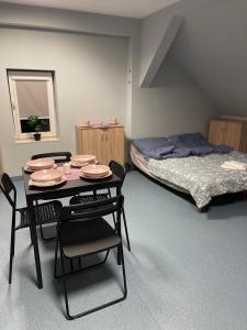 Zimmer mit einem Tisch, Stühlen und einem Bett in der Unterkunft Lawendowa Przystań pokój rodzinny Nr 7 poddasze 