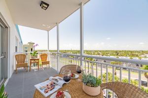 a balcony with a table with wine glasses on it at Oceanfront Beach House, Satellite Beach in Satellite Beach