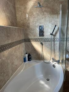 a bathroom with a white tub and a shower at London Mackenzie Suites in London