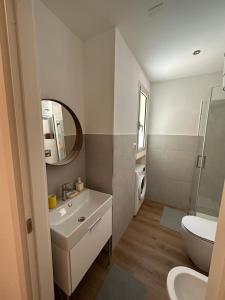 uma casa de banho branca com um lavatório e um WC em CasaTua em Catânia