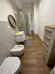 a white bathroom with a toilet and a sink at CasaTua in Catania