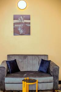 Tammy Homes stay في دار السلام: أريكة في غرفة معيشة مع صورة على الحائط