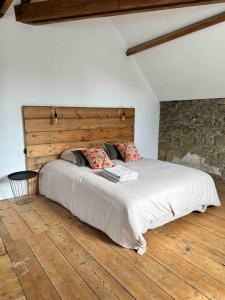 a bedroom with a large bed with a wooden headboard at Maison, type Triplex atypique de charme in Saint-Brieuc