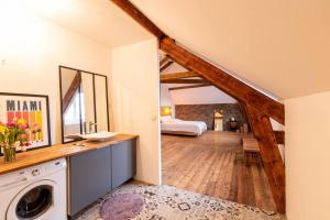 une grande chambre avec un lit et un lave-linge dans l'établissement Maison, type Triplex atypique de charme, à Saint-Brieuc