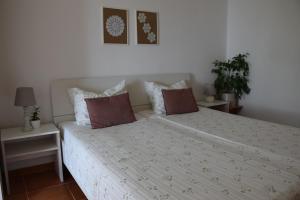 een slaapkamer met een wit bed met 2 kussens bij Apartments Fink in Portorož