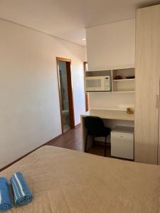 een kamer met een bed, een bureau en een computer bij Suíte Leshalles 311 - no Paris Residencial Service in Lagoa Santa