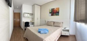 a bedroom with a bed with a blue bag on it at Suíte Leshalles 311 - no Paris Residencial Service in Lagoa Santa