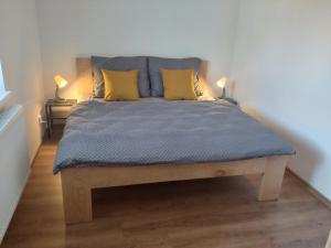 łóżko z dwoma żółtymi poduszkami na górze w obiekcie Apartmán Karlovice - Jeseníky w mieście Karlovice