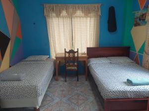 una camera con 2 letti, una scrivania e un tavolo di C.C. Habitaciones a Puerto Baquerizo Moreno