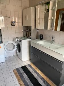 Moderne Ferienwohnung Neckarschleife mit Klimaanlage في Kirchheim am Neckar: مطبخ مع غسالة ملابس وغسالة