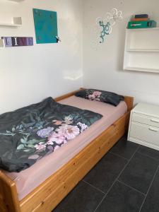 Un dormitorio con una cama de madera con flores. en Moderne Ferienwohnung Neckarschleife mit Klimaanlage, en Kirchheim am Neckar